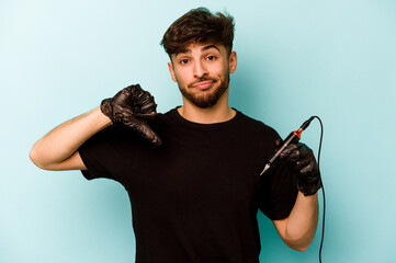 Tattoo artist hispanic man isolated on blue background showing a dislike gesture, thumbs down....