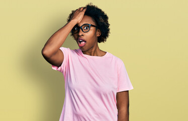 African american woman with afro hair wearing casual clothes and glasses surprised with hand on head for mistake, remember error. forgot, bad memory concept.