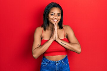 Young african american girl wearing casual style with sleeveless shirt praying with hands together...