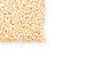 Kernels of peeled pine nuts in vacuum packaging on a white background