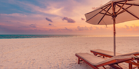 Panoramic sunset beach, chairs under umbrella, dream beautiful sea sand sky. Romantic couples beach, tropical island landscape. Exotic destination, honeymoon, vacation, holiday. Relax, inspire nature