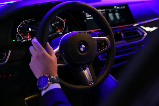 KYIV, UKRAINE, February 1, 2020: Car Interior of new BMW X6 at night, display at the auto show KYIV, UKRAINE. Male hand on a steering wheel driving the new model BMW. 