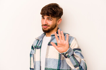 Young hispanic man isolated on white background rejecting someone showing a gesture of disgust.