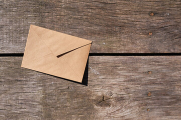 Envelope on a wooden background top view. New mail, message. Postal service. The person wants to...
