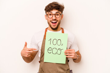 Young gardener man holding 100% eco placard isolated on white background