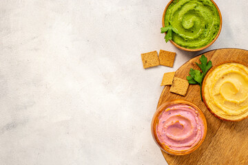 Hummus with spinach and beets in wooden bowls, top view