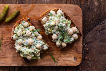 Creamy chickpea salad with avocado, dill, onion and mustard sauce on home made bread