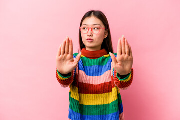 Young Chinese woman isolated on pink background standing with outstretched hand showing stop sign, preventing you. - obrazy, fototapety, plakaty