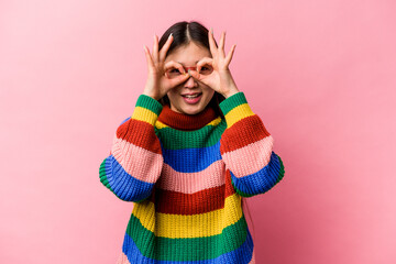 Young Chinese woman isolated on pink background excited keeping ok gesture on eye.