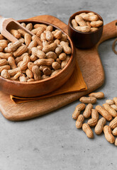 Image of wooden spoons with peanuts on a concrete surface