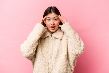 Young Chinese woman isolated on pink background receiving a pleasant surprise, excited and raising hands.