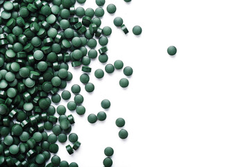 Vegetarian vitamins from Spirulina are scattered on a white background
