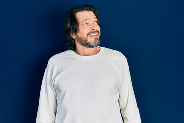 Obraz premium Middle age caucasian man wearing casual clothes looking away to side with smile on face, natural expression. laughing confident.