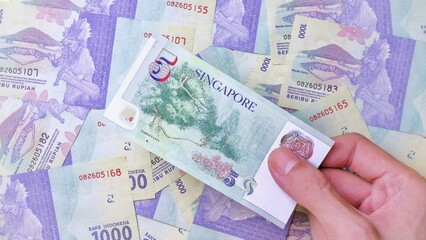 Businessman's hand holding Singapore Dollar Banknotes. Business Investment Economy Saving Loan Income Money and Finance concept. Prosperity concept. Five SGD . 5 SGD. Money Background.