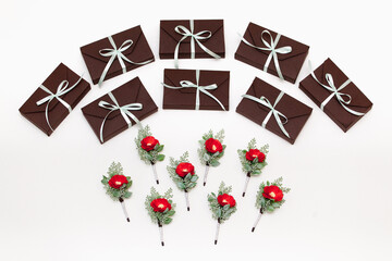 Boutonnieres with red flower and gift boxes on white background