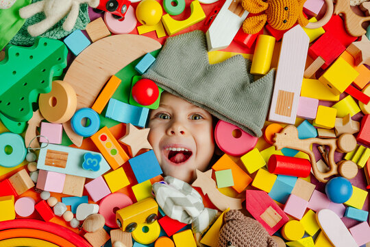 Child's face in the plenty of wooden toys