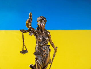 The statue of Lady Justice holding the scales on flag of Ukraine.