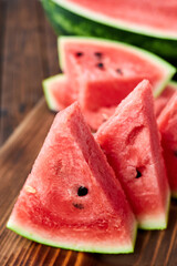 Sliced watermelon on brown wooden background. Close-up, selective focus