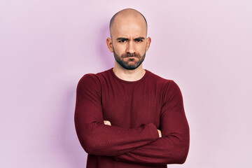 Young bald man wearing casual clothes skeptic and nervous, disapproving expression on face with...