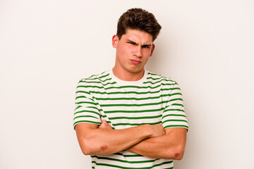 Obraz premium Young caucasian man isolated on white background frowning face in displeasure, keeps arms folded.