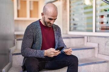 Young man using smartphone and credit card at street