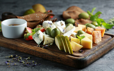 Cheese plate. Appetizer. Sliced hard cheese, cheese with mold, cheddar, camembert with olives,...