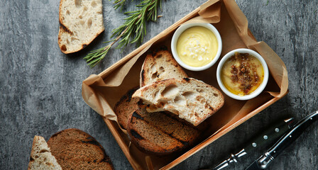 Bread snacks. Toasted bread, croutons with sauce and rosemary on a gray background. White and black...