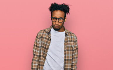 Young african american man with beard wearing casual clothes and glasses skeptic and nervous, frowning upset because of problem. negative person.