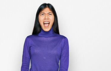 Beautiful young asian woman wearing casual clothes angry and mad screaming frustrated and furious, shouting with anger. rage and aggressive concept.