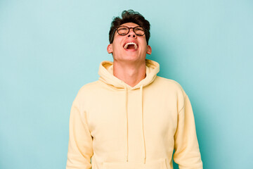 Fototapeta premium Young caucasian man isolated on blue background relaxed and happy laughing, neck stretched showing teeth.