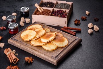 Delicious fresh pancakes on a wooden cutting board with sugar