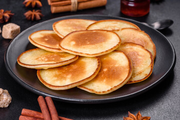 Delicious fresh pancakes on a wooden cutting board with sugar