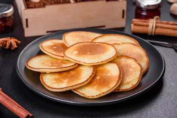 Delicious fresh pancakes on a wooden cutting board with sugar