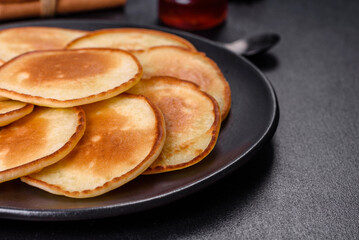 Delicious fresh pancakes on a wooden cutting board with sugar