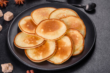 Delicious fresh pancakes on a wooden cutting board with sugar