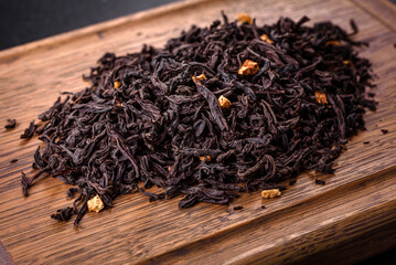 Black Ceylon tea - Top view of black tea background with green leaves