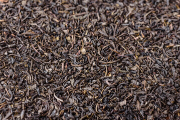 Tea green dry in white saucer on a dark concrete background