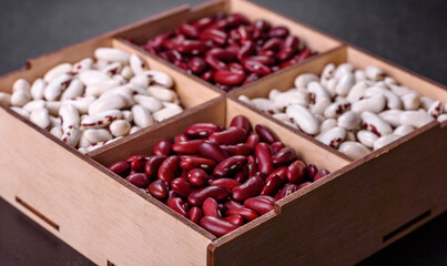 Beans of red and white dry raw beans on a dark concrete background