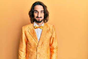 Young hispanic man wearing hipster elegant look puffing cheeks with funny face. mouth inflated with...