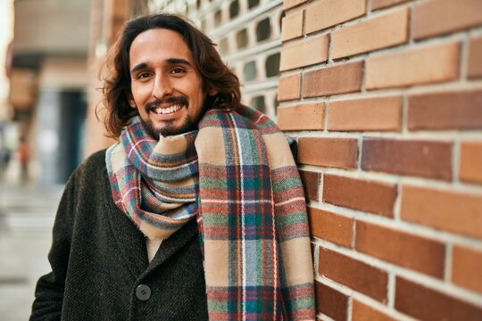 Young hispanic man smiling happy standing at the city.