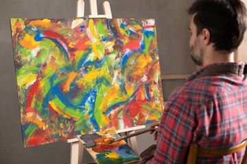 Male artist working with painting. Man artist painter and palettte in creative studio