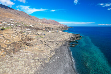 Beautiful coast with blue sea and dry landscape on the volcanic island of El Hierro under blue sky. Drone shot. Vacation on the Canary Islands