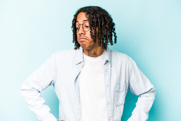 Young African American man isolated on blue background dreaming of achieving goals and purposes