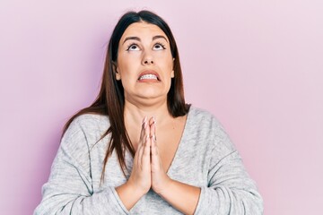 Fototapeta premium Young hispanic woman wearing casual clothes begging and praying with hands together with hope expression on face very emotional and worried. begging.
