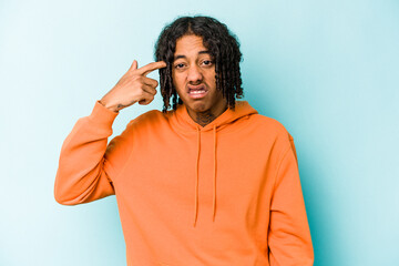 Fototapeta premium Young African American man isolated on blue background covering ears with hands.