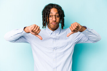 Young African American man isolated on blue background showing a dislike gesture, thumbs down....