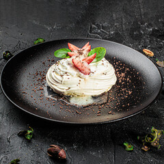 Anna Pavlova cake with cream and fresh strawberries on a dark background. Square image
