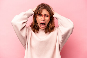 Young caucasian woman isolated on pink background screaming, very excited, passionate, satisfied...