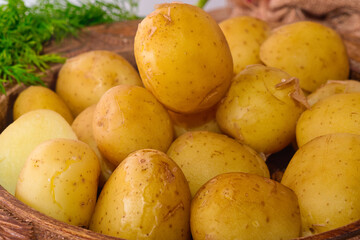 Delicious spring dinner - boiled young potatoes with butter and dill served in the wooden bowl