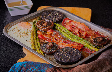 Black pudding and streaky bacon tray bake,with vegetables. 